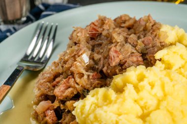 Domuz etli lahana, sosis ve patates püresiyle servis edilen mantarlar. Bigos - geleneksel Polonya mutfağı.