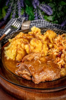 Patates püresi ve salatayla servis edilen acılı soslu domuz pirzolası. Sığ alan derinliği.