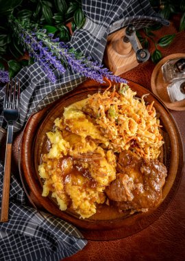 Patates püresi ve salatayla servis edilen acılı soslu domuz pirzolası. Sığ alan derinliği.