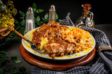 Patates püresi ve salatayla servis edilen acılı soslu domuz pirzolası. Sığ alan derinliği.