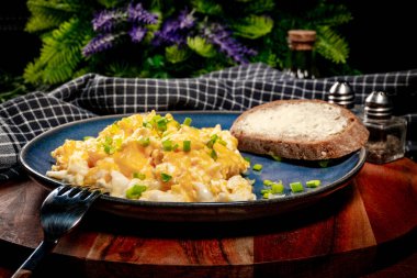 Sahanda yumurta soğan ve Frenk soğanı ile mavi tabakta ekmek ile servis.