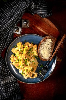 Sahanda yumurta soğan ve Frenk soğanı ile mavi tabakta ekmek ile servis.