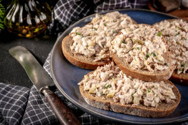 Tahta bir tahtanın üzerinde ton balıklı sandviç ve yumurta. Sığ alan derinliği. 
