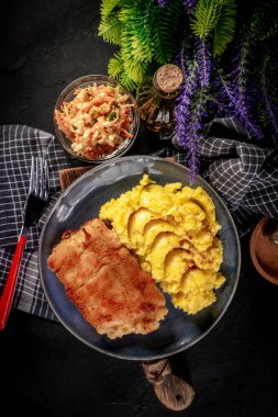 Haşlanmış patates ve sebze salatasıyla servis edilen kızarmış morina filetosu..