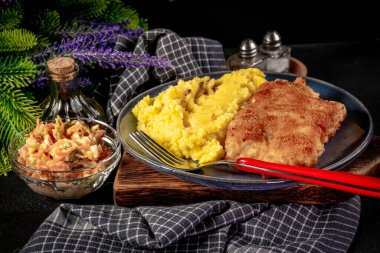 Haşlanmış patates ve sebze salatasıyla servis edilen kızarmış morina filetosu..