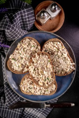 Tahta bir tahtanın üzerinde ton balıklı sandviç ve yumurta. Sığ alan derinliği. 