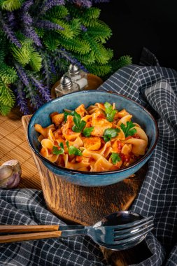 Domates soslu erişteli tavuk parçaları. Sığ alan derinliği.