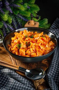 Domates soslu erişteli tavuk parçaları. Sığ alan derinliği.