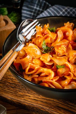 Domates soslu erişteli tavuk parçaları. Sığ alan derinliği.