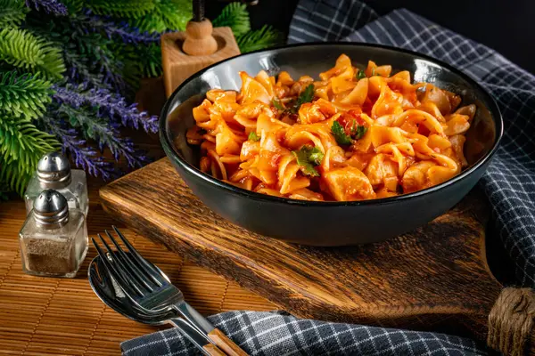 Domates soslu erişteli tavuk parçaları. Sığ alan derinliği.