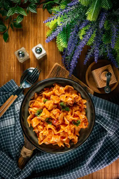 Domates soslu erişteli tavuk parçaları. Sığ alan derinliği.