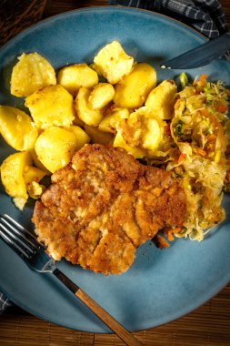 Patates ve salatayla servis edilen domuz boyunlu pirzola. Sığ alan derinliği.