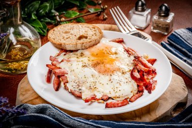 Yağda yumurta ve dilimlenmiş sosis tabakta. Sığ alan derinliği.