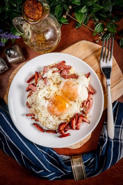 Yağda yumurta ve dilimlenmiş sosis tabakta. Sığ alan derinliği.