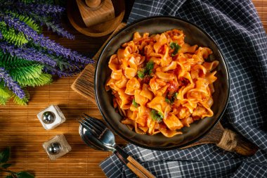 Domates soslu erişteli tavuk parçaları. Sığ alan derinliği.