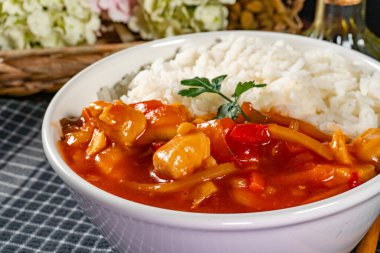 Tatlı ve ekşi soslu lezzetli tavuk pilav ile servis.