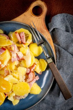 Geleneksel bir Polonya yemeği (pieczonki, prazonki, duszonki) - füme domuz pastırması, sosis ve soğanlı haşlanmış patates.