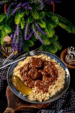 Acı sosla doldurulmuş bulgur groats ile servis edilen sığır kebabı. Sığ alan derinliği.