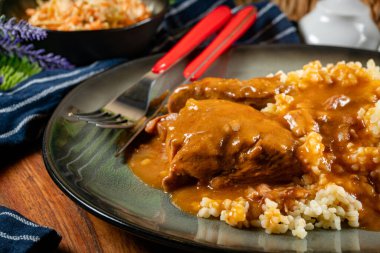 Kendi soslu haşlanmış domuz boyunlu arpa ve salatayla servis ediliyor. Sığ alan derinliği.