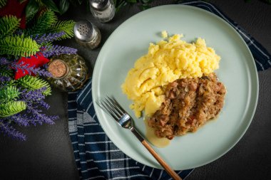 Domuz etli lahana, sosis ve patates püresiyle servis edilen mantarlar. Bigos - geleneksel Polonya mutfağı.