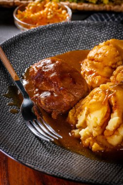 Geleneksel Alman haşlanmış kahverengi soslu domuz yanakları patates püresiyle servis edilir..