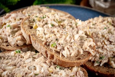 Tahta bir tahtanın üzerinde ton balıklı sandviç ve yumurta. Sığ alan derinliği. 