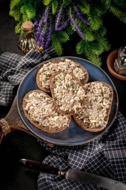 Tahta bir tahtanın üzerinde ton balıklı sandviç ve yumurta. Sığ alan derinliği. 