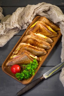 Tabakta kızarmış peynirli sandviç. Yüzeyin derinliği. Üst görünüm.