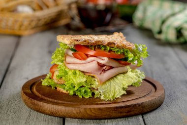 Sandviç ile jambon, salatalık, domates, marul, dolum üç dilim kızarmış ekmek arasında iki kat ile.