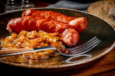 Tabakta soğanlı kızarmış sosis. Sığ alan derinliği.