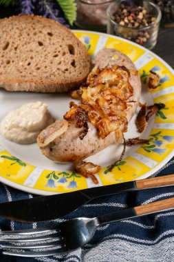 Kızarmış beyaz sosis, soğanlı ve rendelenmiş yaban turpu. Küçük alan derinliği.