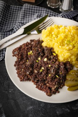 Kızarmış puding, patates püresi ve salatalık turşusu..