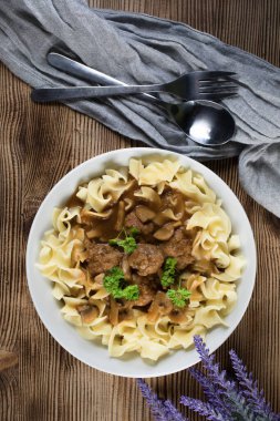 Tagliatelle yosunuyla servis edilen kendi soslu mantarlı domuz köftesi..