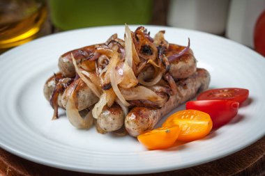 Kızarmış beyaz sosis tabakta soğan ile. Seçici odak.