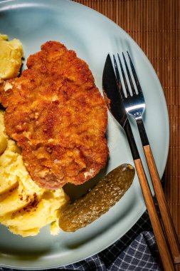 Patates ve salatalık turşusu ile servis edilen domuz pirzolası..