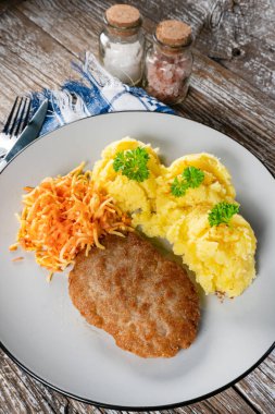 Patates püresi ve havuç salatasıyla servis edilen ev yapımı kıymalı pirzola..