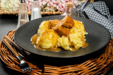 Patates püresi ve rendelenmiş pancar ile servis edilen soslu domuz buğulama. Yüzeyin derinliği.