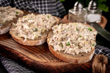 Tahta bir tahtanın üzerinde ton balıklı sandviç ve yumurta. Sığ alan derinliği. 