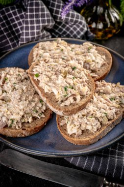 Tahta bir tahtanın üzerinde ton balıklı sandviç ve yumurta. Sığ alan derinliği. 