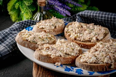 Tahta bir tahtanın üzerinde ton balıklı sandviç ve yumurta. Sığ alan derinliği. 