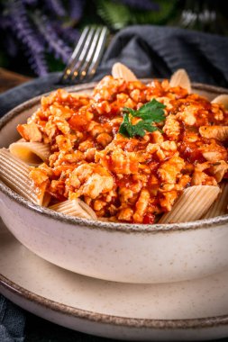 Domates soslu doğranmış tavuk etli makarna. Sığ alan derinliği.