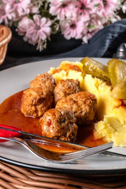 Ev yapımı hızlı yemek. Köfte, domuz eti ve üzerine kırmızı biber sosu sürülmüş patates püresi. Seçici odak.