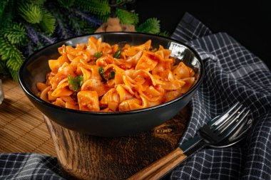 Domates soslu erişteli tavuk parçaları. Sığ alan derinliği.