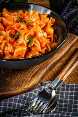 Domates soslu erişteli tavuk parçaları. Sığ alan derinliği.