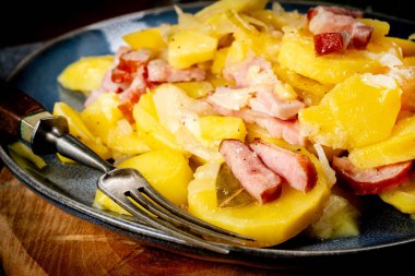 Geleneksel bir Polonya yemeği (pieczonki, prazonki, duszonki) - füme domuz pastırması, sosis ve soğanlı haşlanmış patates.