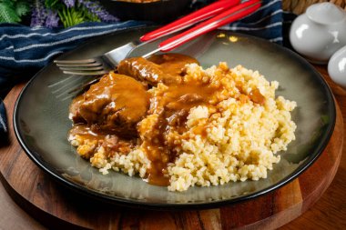 Kendi soslu haşlanmış domuz boyunlu arpa ve salatayla servis ediliyor. Sığ alan derinliği.