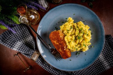 Haşlanmış patatesle servis edilen kızarmış balık filetosu..