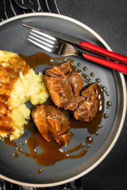 Sos ve patates püresiyle servis edilen haşlanmış hindi eti. Sığ alan derinliği.