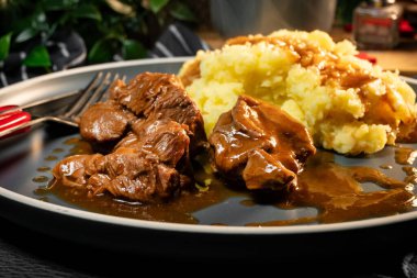 Sos ve patates püresiyle servis edilen haşlanmış hindi eti. Sığ alan derinliği.