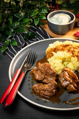 Sos ve patates püresiyle servis edilen haşlanmış hindi eti. Sığ alan derinliği.